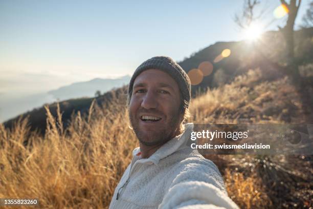 man hiking takes a selfie at sunset - self portrait photography stock pictures, royalty-free photos & images