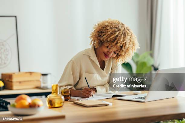 schöne glückliche frau, die von zu hause aus an ihrem laptop arbeitet - einzelne frau über 40 stock-fotos und bilder