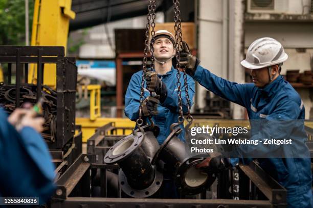 blue collar workers working in steel factory - steel factory stock pictures, royalty-free photos & images
