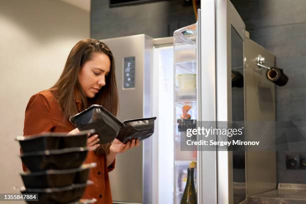 woman checking expiry date of food - use by label ストックフォトと画像