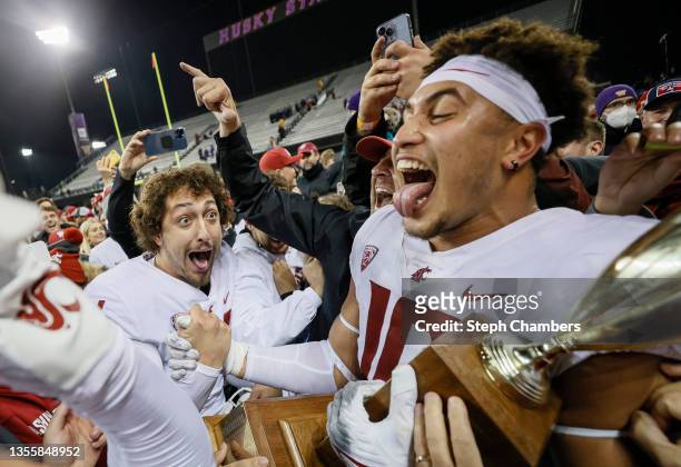 Gabriel Lopez and Ron Stone Jr. #10 of the Washington State Cougars celebrate with the Apple Cup after defeating the Washington Huskies 40-13 at...