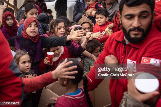 Displaced Syrian children wait to receive toys handed out by Turkish Red Crescent employees at a camp for displaced people supported by the Turkish...