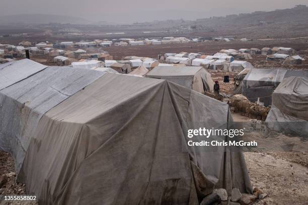 Displaced Syrian woman stands amongst tents inside the Kefer Losing camp run by the Turkish Red Crescent on the outskirts of Idlib, on November 25,...