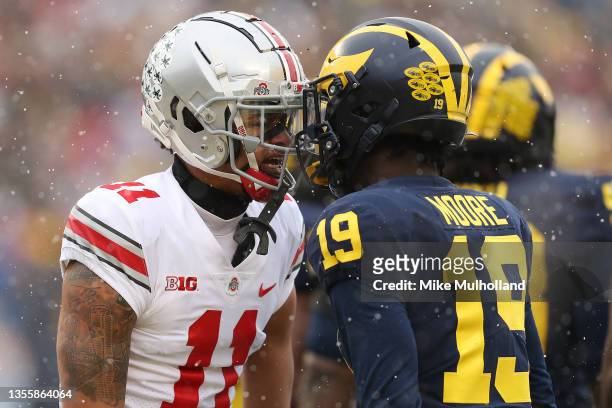 Jaxon Smith-Njigba of the Ohio State Buckeyes and Rod Moore of the Michigan Wolverines talk during the first quarter at Michigan Stadium on November...