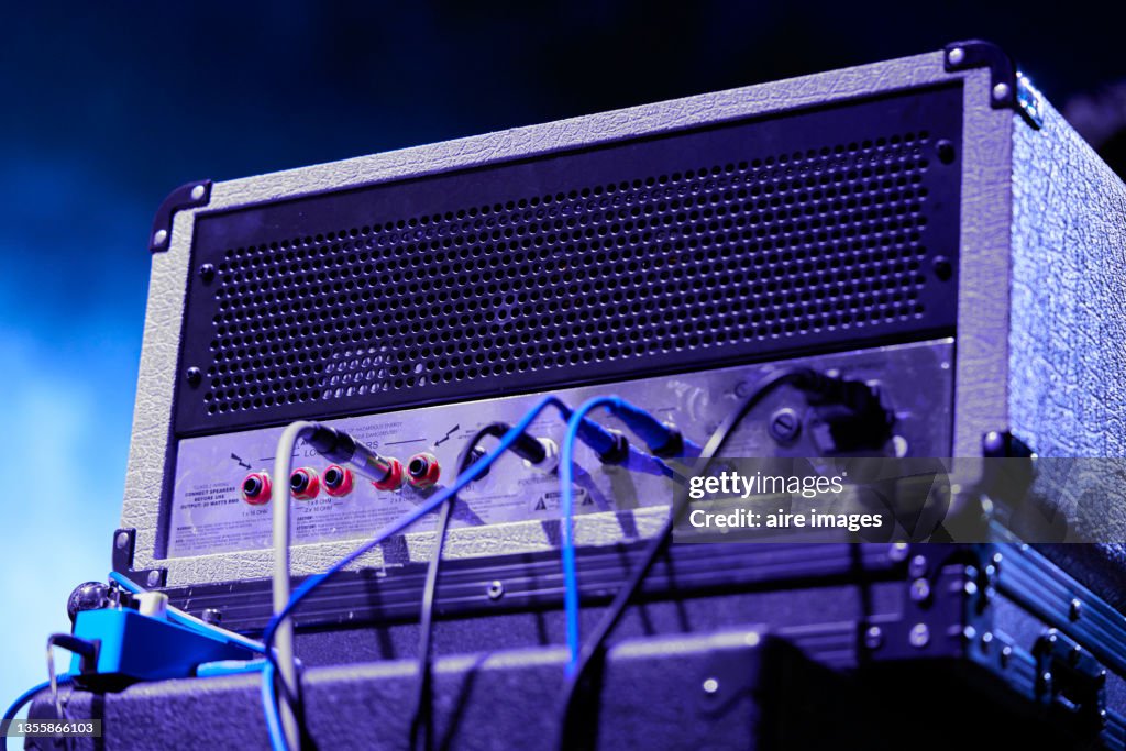 Low angle view of back view of concert audio amplifier and cables on a blurred background