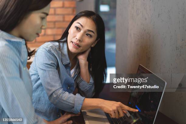 asian professional cryptocurrency trader explaining how to buy the bitcoin to a friend - market risk stock pictures, royalty-free photos & images
