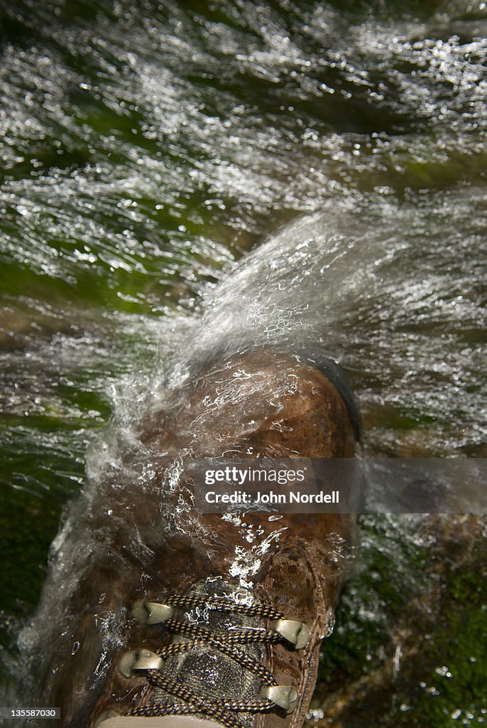 Man steppin on rock in rushing river