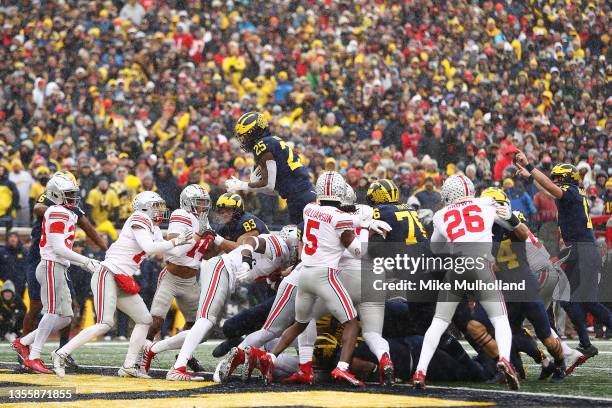 Hassan Haskins of the Michigan Wolverines jumps into the end zone for a touchdown against the Ohio State Buckeyes during the second quarter at...