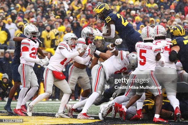 Hassan Haskins of the Michigan Wolverines jumps into the end zone for a touchdown against the Ohio State Buckeyes during the second quarter at...