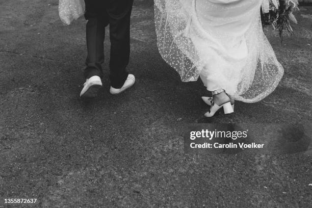rear view of newlyweds walking away on a city street - rural scene wedding stock pictures, royalty-free photos & images