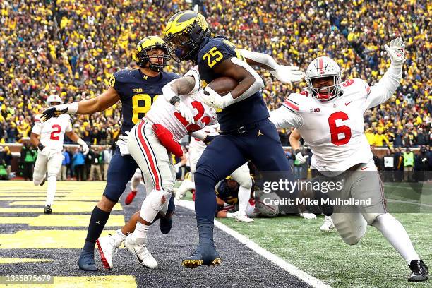 Hassan Haskins of the Michigan Wolverines carries the ball into the end zone for a touchdown in the third quarter against the Ohio State Buckeyes at...