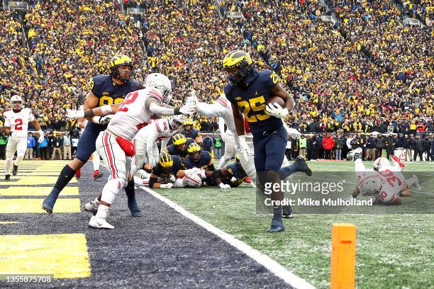 Hassan Haskins of the Michigan Wolverines carries the ball into the end zone for a touchdown in the third quarter against the Ohio State Buckeyes at...