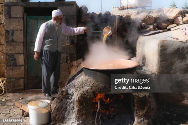 şömine ateşi üzerinde kurulan kazanlarda pekmez yapan adam - molasses stock pictures, royalty-free photos & images