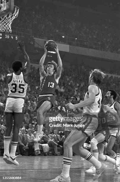 Portland Trail Blazers point guard Dave Twardzik jumps over Denver Nuggets forward Paul Silas in a driving layup during an NBA playoff game at...