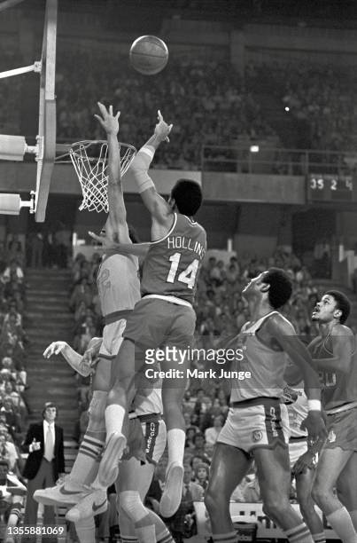 Portland Trail Blazers point guard Lionel Hollins shoots a one-handed floating layup over Denver Nuggets forward Willie Wise during an NBA playoff...