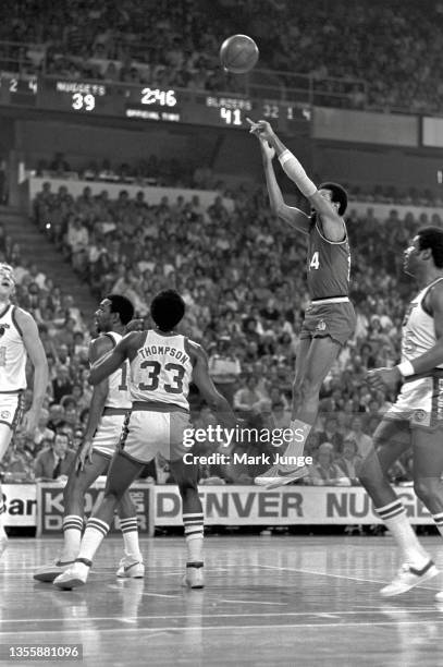 Portland Trail Blazers point guard Lionel Hollins shoots a fall-away jumper over Denver Nuggets forward David Thompson near the free throw line...