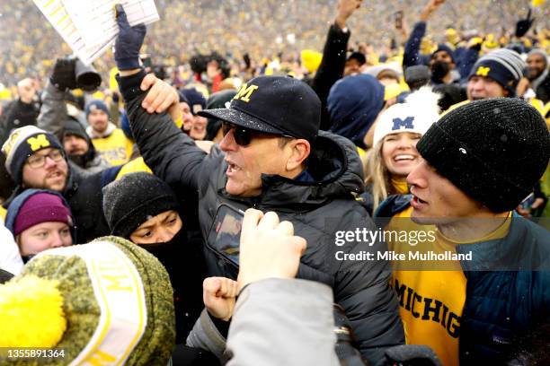 Head Coach Jim Harbaugh of the Michigan Wolverines celebrates with fans after defeating the Ohio State Buckeyes at Michigan Stadium on November 27,...