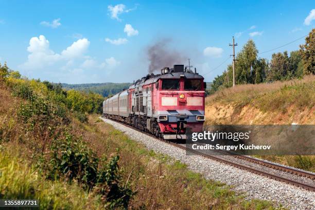 powerful diesel locomotive with passenger train - lokomotive stock-fotos und bilder