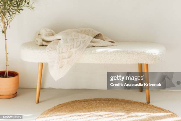 fluffy fur bench, wicker rug and olive plant in ceramic vase. - wool blanket stock pictures, royalty-free photos & images