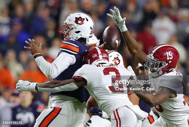 Finley of the Auburn Tigers is pressured by Daniel Wright and Dallas Turner of the Alabama Crimson Tide in the second overtime at Jordan-Hare Stadium...
