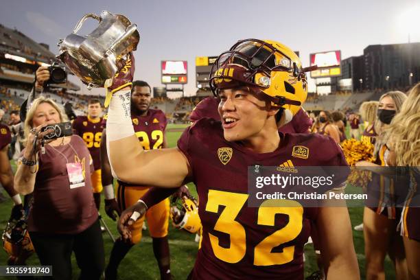 Running back Jackson He of the Arizona State Sun Devils celebrates with the Territorial Cup after defeating the Arizona Wildcats at Sun Devil Stadium...