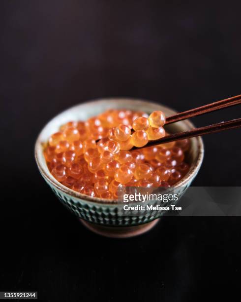 close up of chopsticks holding ikura salmon roe in bowl - ikura bildbanksfoton och bilder