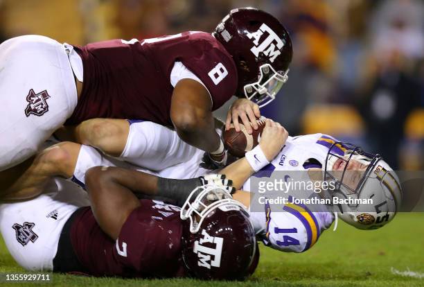 Max Johnson of the LSU Tigers is sacked by DeMarvin Leal and Micheal Clemons of the Texas A&M Aggies during the second half at Tiger Stadium on...