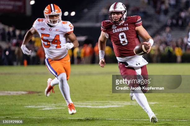 Quarterback Zeb Noland of the South Carolina Gamecocks scrambles with the ball while pursued by linebacker Jeremiah Trotter Jr. #54 of the Clemson...