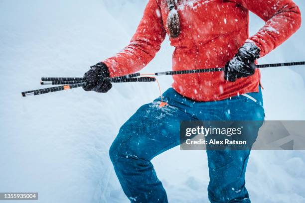 a female backcountry skier packs up a collapsible avalanche probe - wilderness rescue stock pictures, royalty-free photos & images