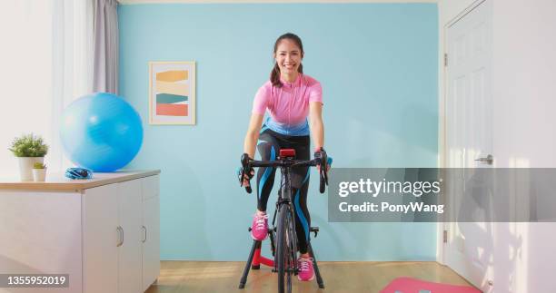 女性はホームバイクに乗る - peloton ストックフォトと画像