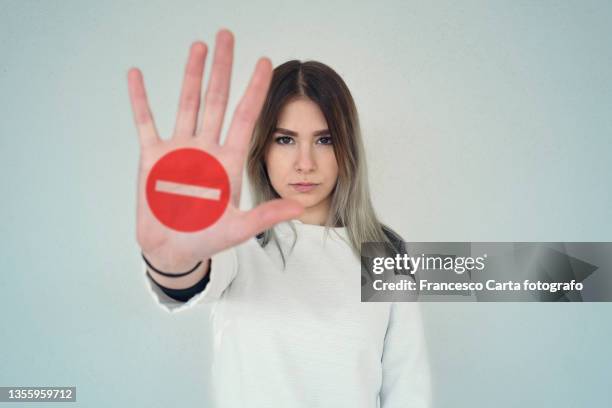 woman holding out her hand as a stop sign - stop fotografías e imágenes de stock