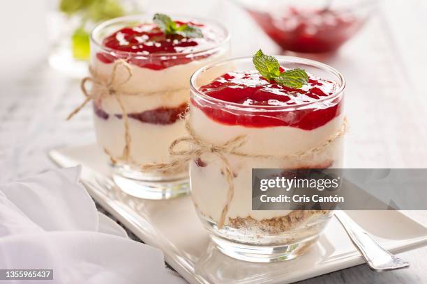 two glasses of strawberry cheesecake on table - dessert topping stock pictures, royalty-free photos & images
