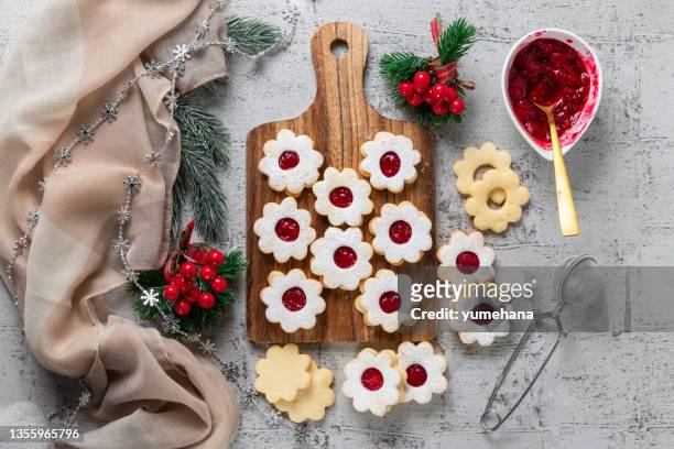linzer christmas or new year cookies filled with jam and dusted with sugar on gray background. - fruits table top stockfoto's en -beelden
