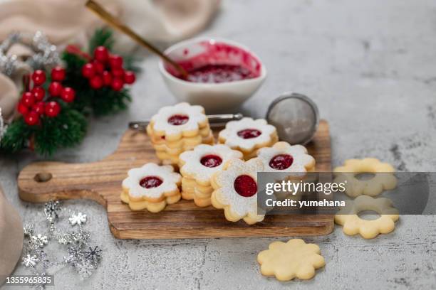 linzer christmas or new year cookies filled with jam and dusted with sugar on gray background. - marmalade sandwich stock pictures, royalty-free photos & images