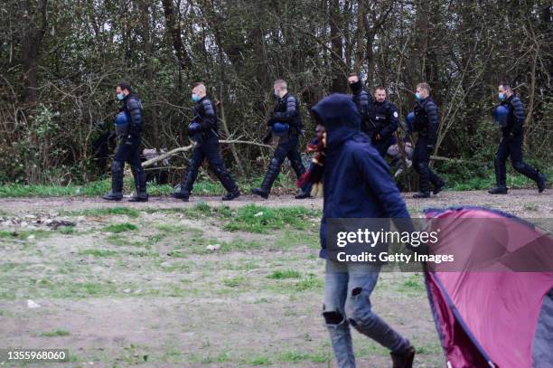 Police officers evict migrants from a camp on November 28, 2021 in Calais, France. The eviction comes as France convened regional officials to...