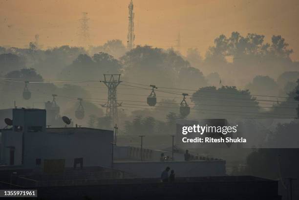 Line of cable trolleys transports coal from a mine to thermal power stations on a smoggy morning on November 23, 2021 in Sonbhadra, Uttar Pradesh,...