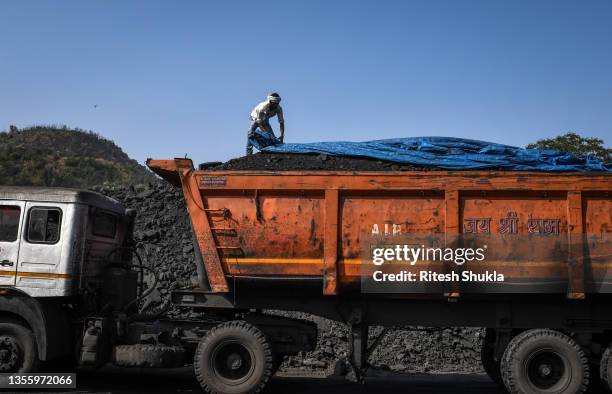 Worker loads coal onto a truck at a coal yard near a mine on November 23, 2021 in Sonbhadra, Uttar Pradesh India. India is rapidly transitioning to...