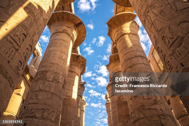 visiting karnak temple, luxor, egypt. columns in the peristyle court - temples of karnak stock pictures, royalty-free photos & images