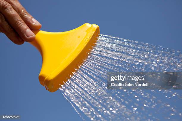 yellow plastic hose nozzle with water shooting out - squirting stock pictures, royalty-free photos & images