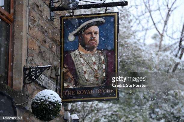 The Royal Dyche pub sign is pictured as snow falls prior to the Premier League match between Burnley and Tottenham Hotspur at Turf Moor on November...