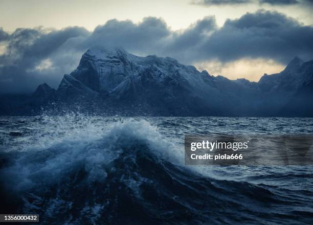 vista sobre un mar agitado, con olas e islas lofoten de fondo - lofoten fotografías e imágenes de stock