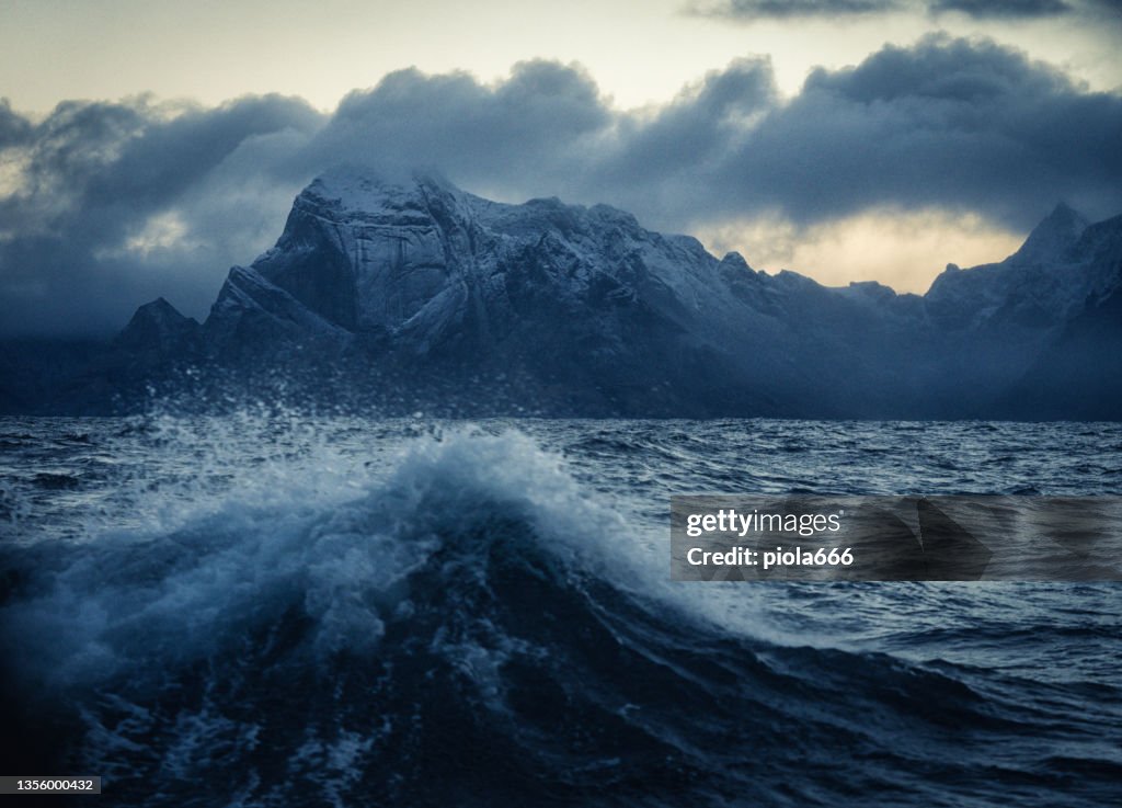 View on a rough sea, with waves and Lofoten Islands on background