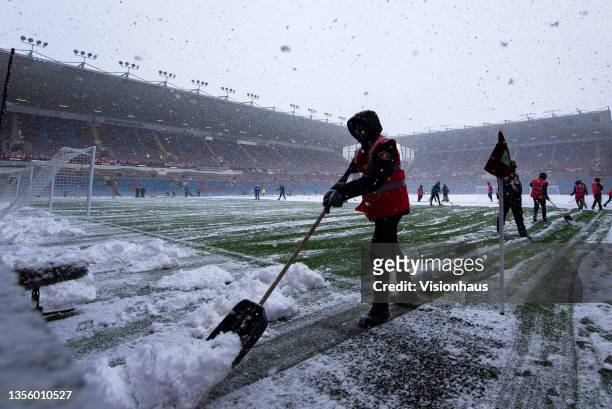 Grounds man shovelling snow off the pitch before the postponed Premier League match between Burnley and Tottenham Hotspur at Turf Moor on November...