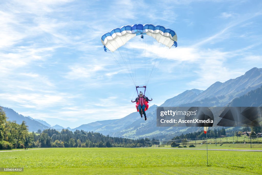 Paraglider comes in to land on grassy meadow