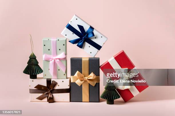 festive christmas new year background colorful gift boxes and holiday decorations on pink background. new year's present and christmas present top view - boîte cadeau photos et images de collection