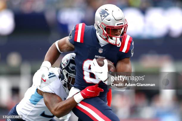 Kevin Byard of the Tennessee Titans tackles Jonnu Smith of the New England Patriots in the first quarter at Gillette Stadium on November 28, 2021 in...