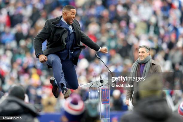 Former New York Giants player Michael Strahan jumps during the ceremony to retire his number at half time of the game between the Philadelphia Eagles...