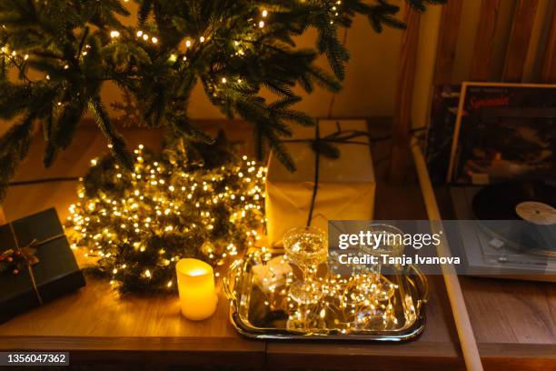 turntable vinyl record player next to the gift and glasses of champagne and christmas lights. analog retro vintage - vintage record player no people ストックフォトと画像