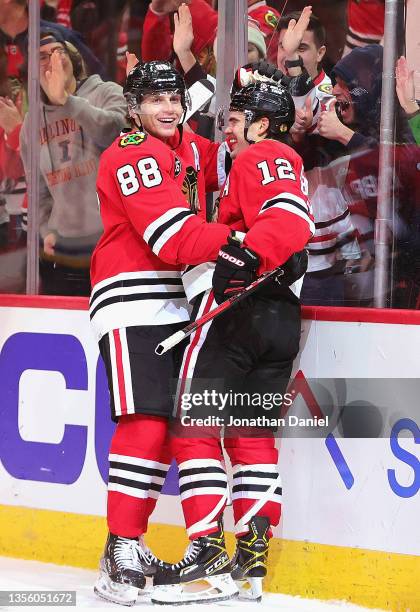 Patrick Kane and Alex DeBrincat of the Chicago Blackhawks celebrate combining on the game-winning goal against the St. Louis Blues at the United...