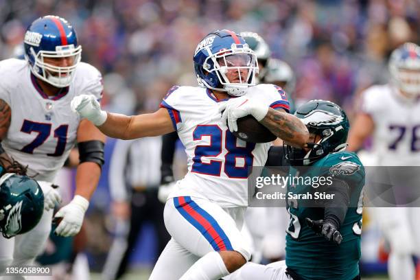 Devontae Booker of the New York Giants runs with the ball past Derek Barnett of the Philadelphia Eagles in the third quarter at MetLife Stadium on...